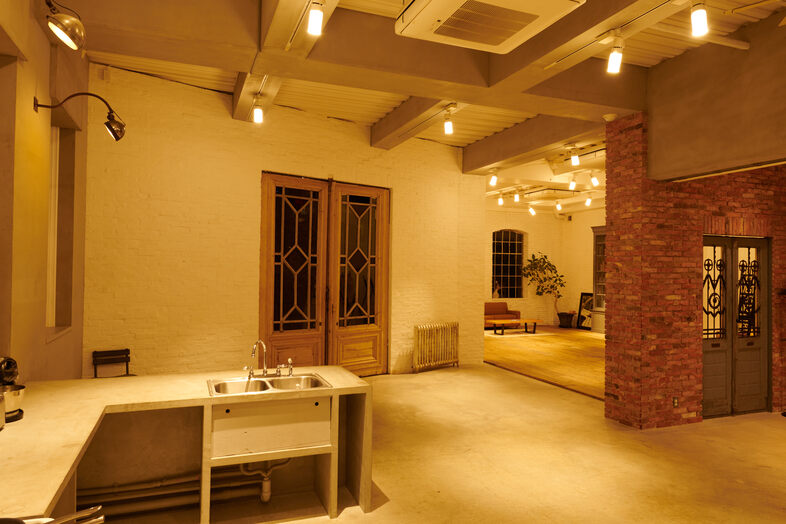 STUDIO EASE砧 4F -ATELIER-｜レンガ壁とキッチンを一画面に収めた夜の室内