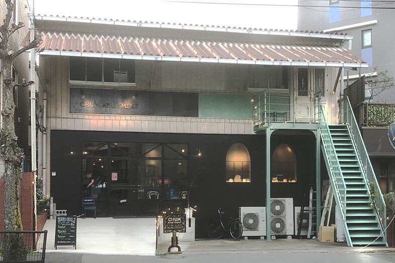 CHUM APARTMENT｜【外観】黒い外壁とグリーンの外階段が印象的な店舗外観