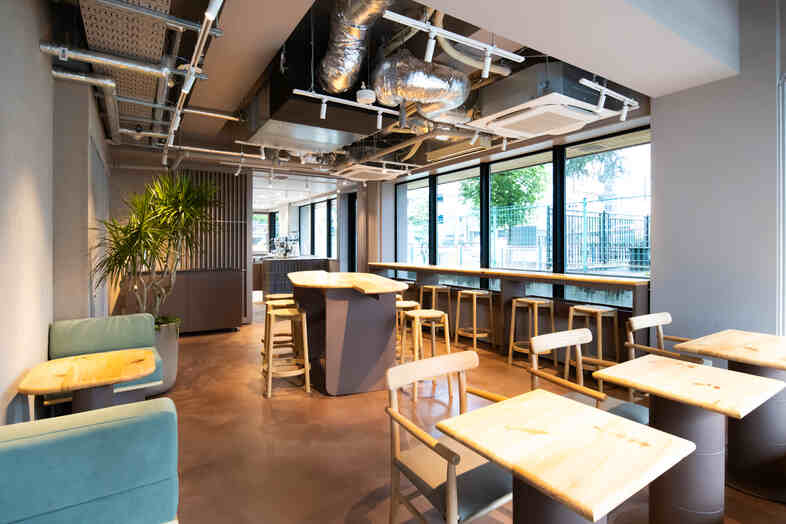 WAND-CAFE-｜ソファとテーブル席を備えた店内で日常のワンシーンを