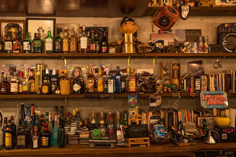 HAPPY MOUNTAIN BAR｜多彩なボトルや雑貨が並ぶ棚を背景に、バーの雰囲気を活かした撮影が可能