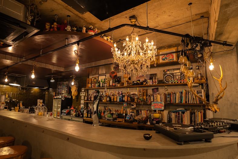 HAPPY MOUNTAIN BAR｜シャンデリアと個性的な装飾が目を引くバーカウンター